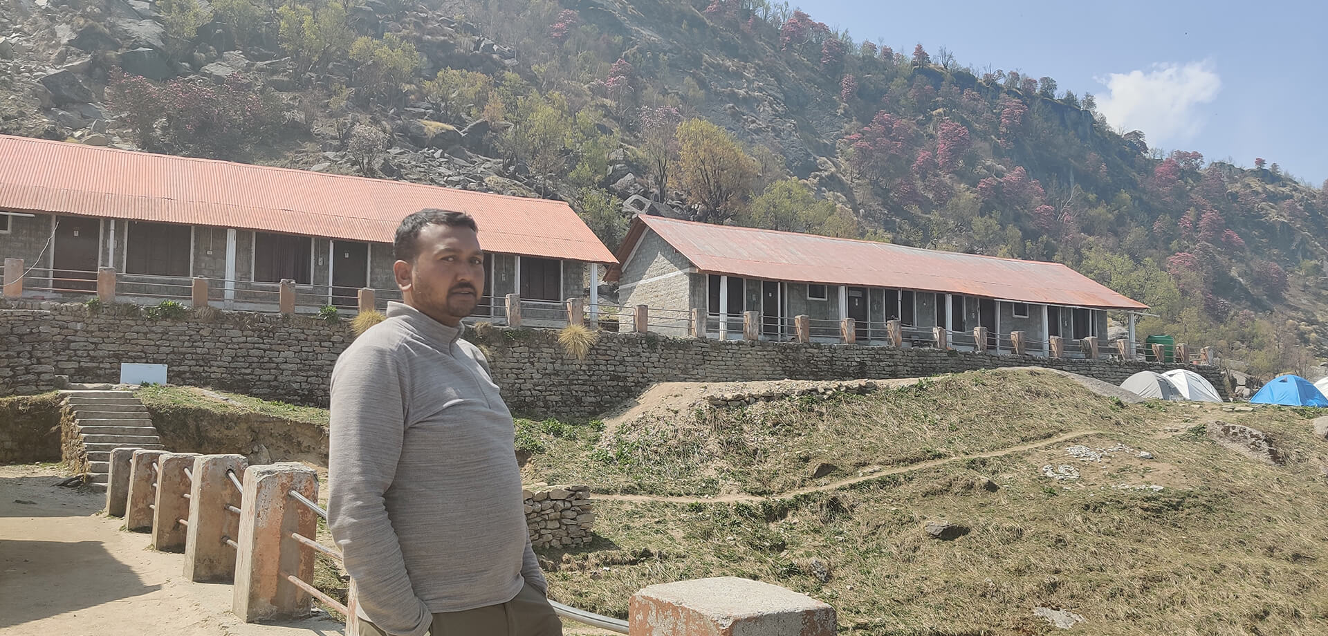 A tourism entrepreneur in front of his guest house 