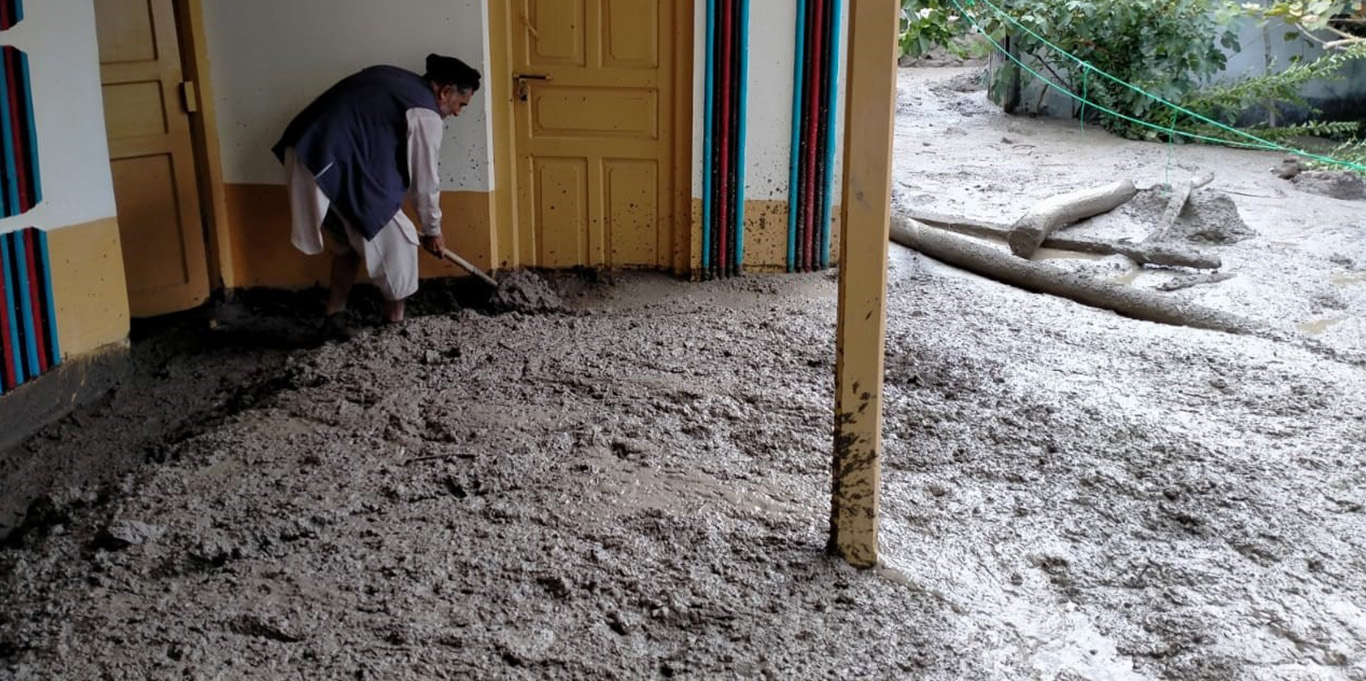 A villager clears away debris