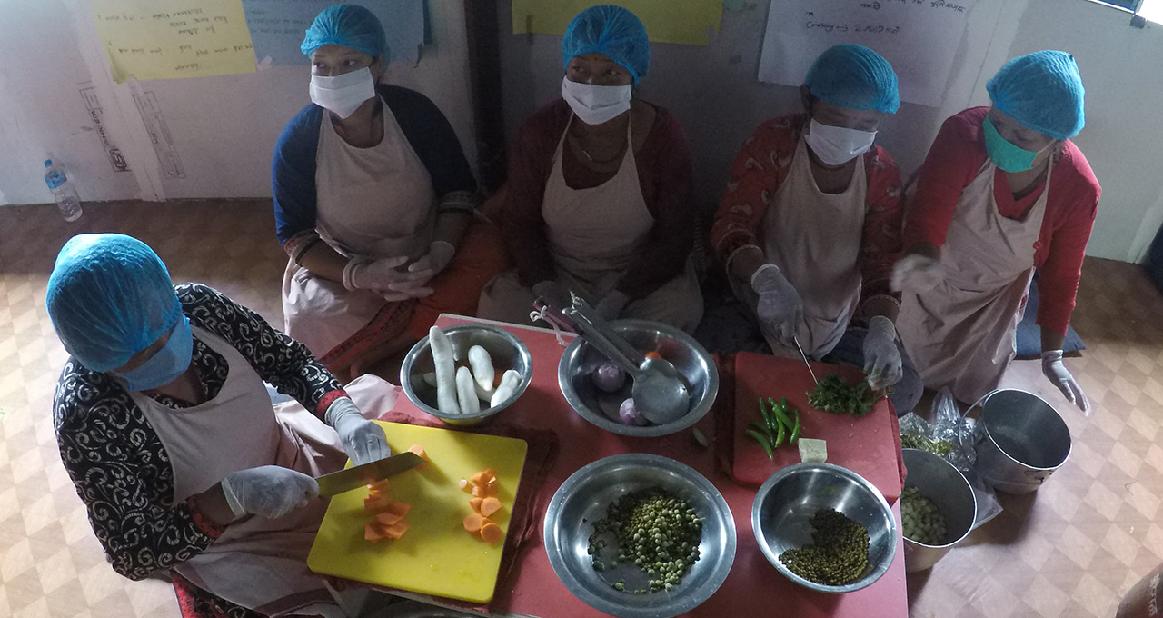 Women prepare vegetables for packaging and sale at one of SABAH